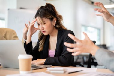 Asyalı iş kadını başını ağrıtıyor ya da ofis masasındaki bir iş yeri anlaşmazlığı yüzünden strese giriyor. Toplantı odası, şirket işleri, modern şirket..