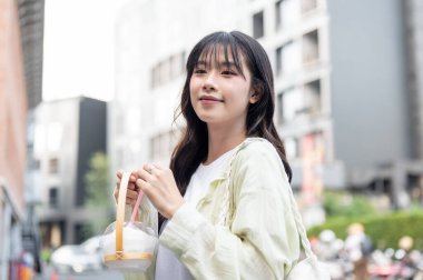 Güzel Asyalı kadın turist elinde bardaklıkla elinde hindistan cevizi tutarken ya da alışveriş merkezinde yürürken. Tek başına yolculuk, şehir turu, açık havada dinlenme..