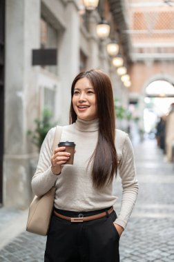 Alışveriş merkezinde el ele dururken elinde kahve poşeti tutan güzel Asyalı kadın. Boş zaman, Solo gezi, Seyahat Turisti.