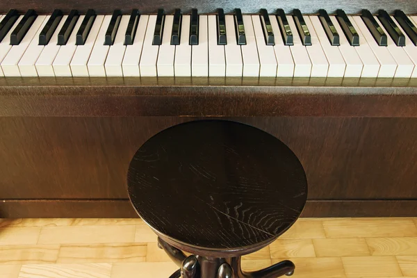 Llaves de piano con silla en la habitación interior —  Fotos de Stock