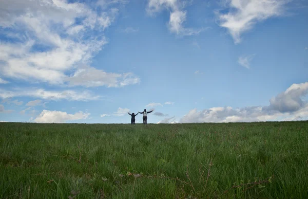 Amor casal correndo através de grama campo — Fotografia de Stock