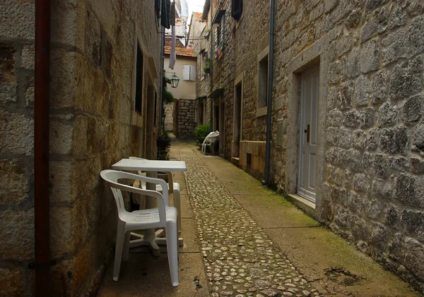 Vecchia strada romantica con sedie di plastica — Foto Stock