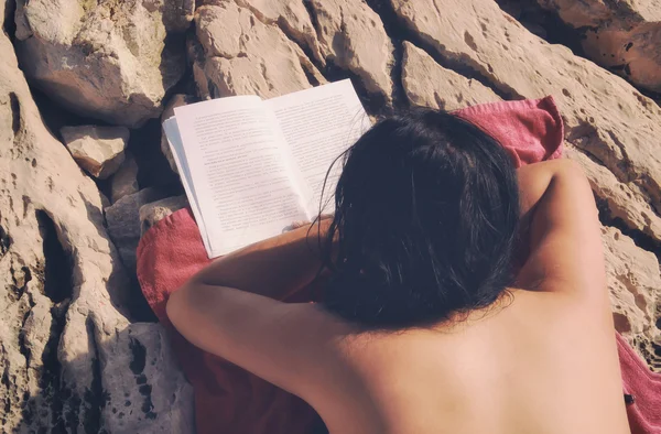 Ragazza sta leggendo un libro su Rocky Beach — Foto Stock