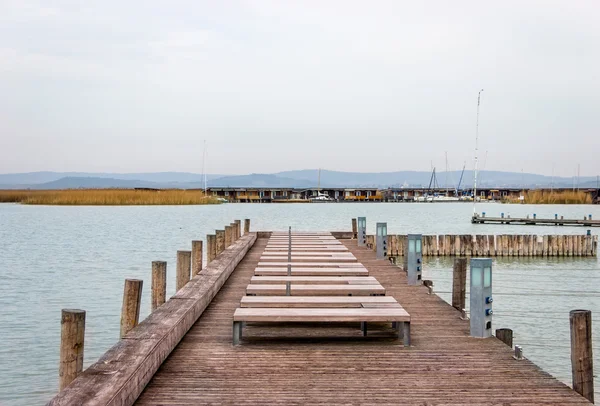 Masse en bois sur le lac avec des yachts dans les quais — Photo