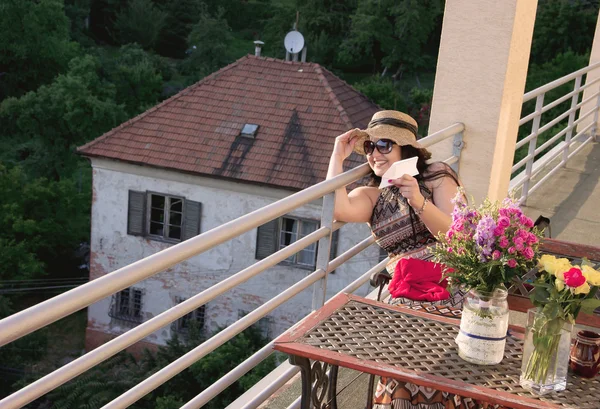 Женщина на балконе на закате — стоковое фото
