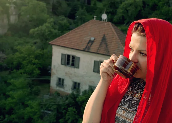 Vrouw is drinken koffie op het balkon — Stockfoto