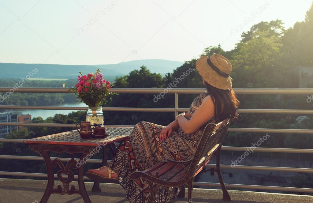 Woman is Drinking Coffee on Balcony