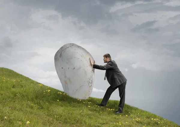 Businessman Pushing Rock Uphill — Stock Photo, Image