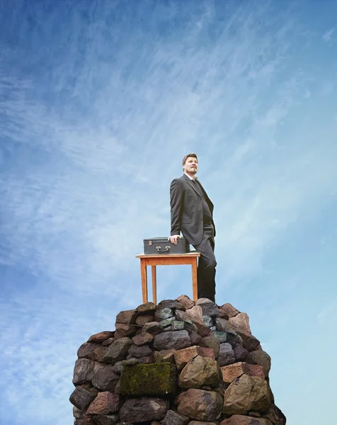 Επιτυχημένος επιχειρηματίας που στέκεται πάνω σε πέτρινη βάθρο — Φωτογραφία Αρχείου