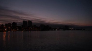 Akdeniz kıyısında bulutlar ve şehrin arka planında zaman atlaması