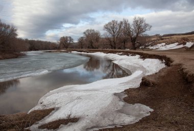 Nehir ilkbaharın başlarında kıyılarda kar artıklarıyla.