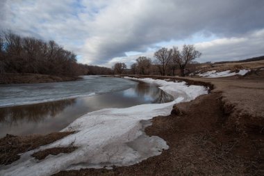 Nehir ilkbaharın başlarında kıyılarda kar artıklarıyla.