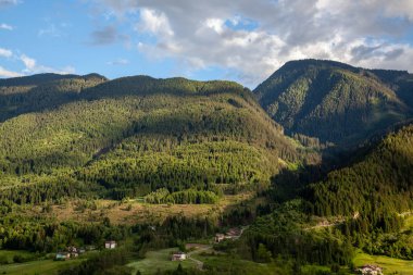 Ormanlar arasında Alpler 'de bir köy, dağ zirvelerinin arka planına karşı..