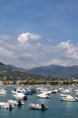 Dağların ve şehrin arka planına karşı denizdeki yatlar.