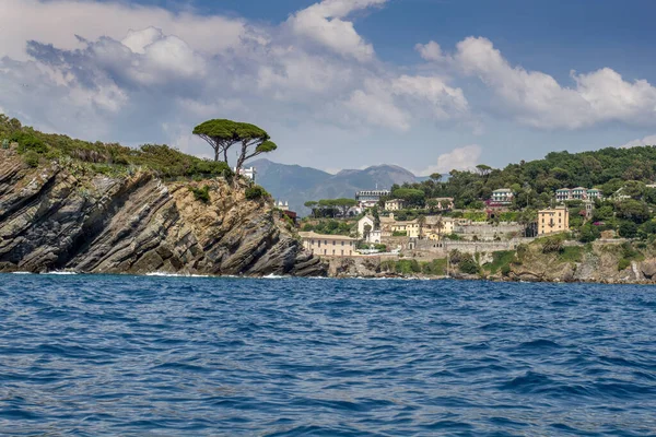 前景一片蓝水的海景 背景是意大利港口城市和岩石海岸线 — 图库照片