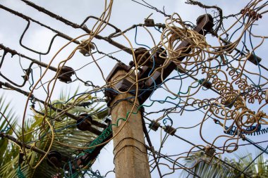 Konut evlerine elektrik sağlayan bir direkteki elektrik kablolarının görüntüsü