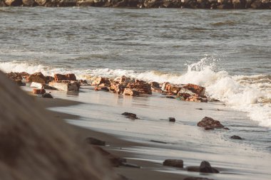 Dalgalar Kovalam Sahili, Chennai, Hindistan boyunca tuğla kalıntıları üzerinde sıçradı.