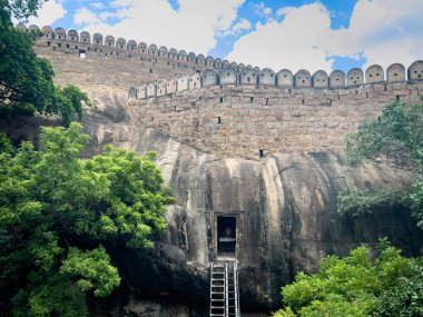 Zengin yeşilliklerle çevrili, Pudukkottai bölgesindeki Thirumayam Kalesi 'nin büyük tahkimat duvarlarına giriş yapan antik kaya kesimli Shiva tapınağı..