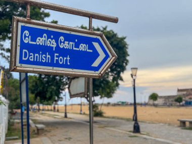 Tharangambadi, Tamil Nadu, Hindistan - 24 Eylül 2025: Tamil Nadu 'da tarihi bir 17. yüzyıl kolonisi olan Tharangambadi' deki Danimarka Kalesi 'ni (Dansborg Kalesi) işaret eden Tamil ve İngilizce tabela.