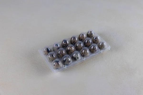 プラスチック包装に卵をウズラ 卵を保護するためにプラスチック封筒 ベージュ色の背景に ファーマーズマーケットの卵 — ストック写真