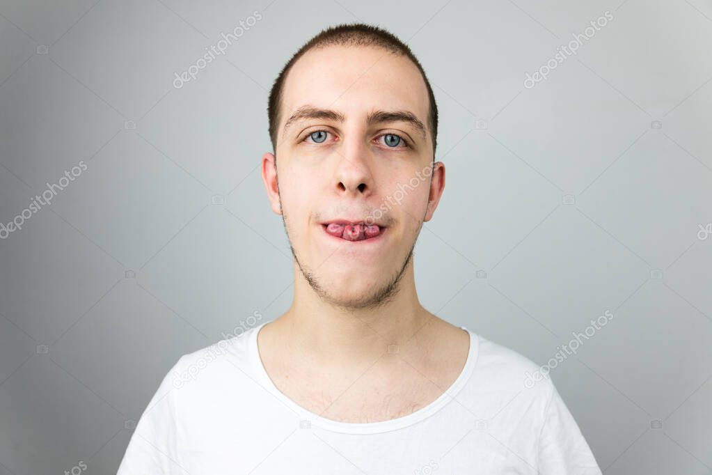 Close up of a young man, folding his tongue in a rare tri fold, clover leaf shape. Strange genetic ability. White Caucasian male on white background
