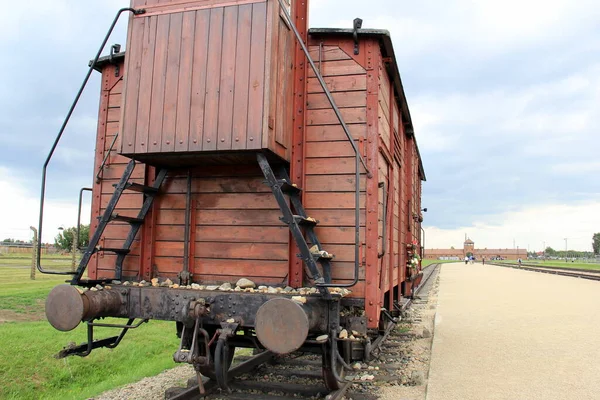 Infamous rail car, gate house with guard tower in the background, of Auschwitz concentration camp, Oswiecim, Poland - June 26, 2012