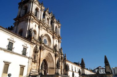 Alcobaca Manastırı, kilisenin ana kapısı ve gül penceresi Gotik (13. yüzyılın başları) iken, kuleler Barok (18. yüzyıl), Alcobaca, Portekiz - 8 Ağustos 2016
