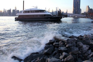 Williamsburg 'a yanaşan banliyö teknesi, Doğu Nehri sörfü, gün batımında alacakaranlıkta, New York, New York, New York, ABD - 18 Temmuz 2020