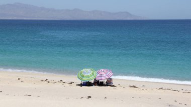 Cortes Denizi kıyısında iki plaj şemsiyesi, Punta Arena de La Ventana, BCS, Meksika - 1 Mayıs 2021