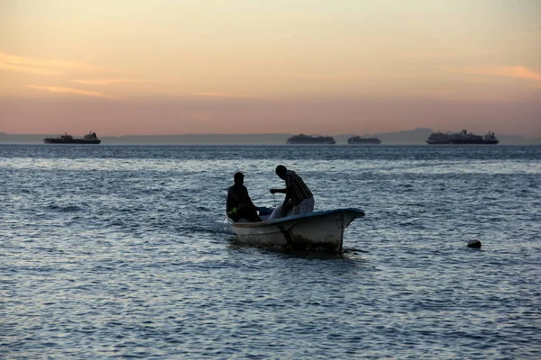 Liten Fiskebåt Bakgrunden Solnedgången Himlen Två Silhuetter Fiskare Ombord Paz — Stockfoto