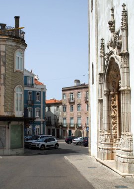 Street scene at the Square Viscount Serra do Pilar in historic center, gothic portal of the Santa Maria de Marvila Church on the right, Santarem, Portugal - July 11, 2021