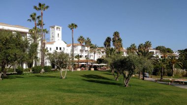 Palmiye ağaçları ve subtropikal bitki örtüsü arasındaki beyaz tatil beldesi, Algarve, Portekiz - Ocak 2017