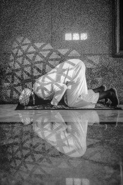 muslim man having worship and praying for allah blessing in islam ceremony in mosque during islamic ramadan period in black and white clipart