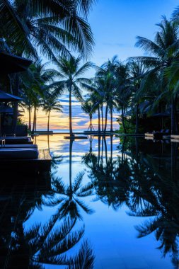 Havuz manzarası ve havuz kenarındaki bangalov Huahin Tayland 'daki tatil köyü ve oteli. Gün doğarken mavi gökyüzü.