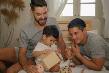 Kafkasyalı eşcinsel çift evlâtlık oğullarıyla oynuyorlar. LGBTQ konsepti Evlatlık çocukla eşcinsel çift ilişkisi