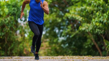 Atletik sporcu koşucu sabah parkta koşu antrenmanı yapıyor. Sporcu yaşam tarzı konsepti