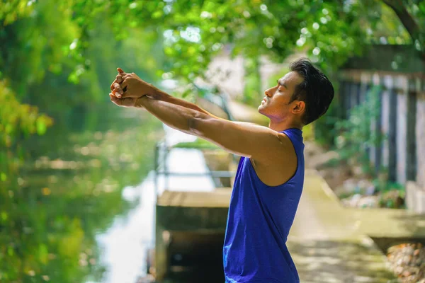 asian young athletic sport man having relax and leg stretching after jogging workout outdoors in park in morning. concept of athletic sport people lifestyle. concept of athletic sport people lifestyle