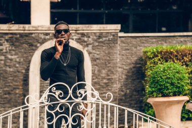 Sigara içen ve fotoğraf için poz veren Afrikalı modelin portresi.