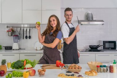 Kafkasyalı çift fotoğraf çekmek ve evde sağlıklı yemek pişirmek için birlikte iyi vakit geçiriyorlar.