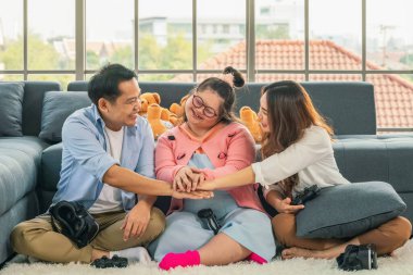 Asyalı Down sendromlu genç kız evde anne ve babasıyla birlikte 3 boyutlu konsol oyunu oynarken eğleniyor.