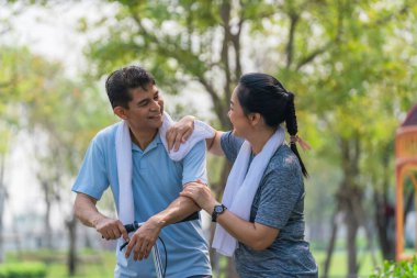 Asyalı çift parkta motosikletle spor yapıyor ve spor yapıyor.