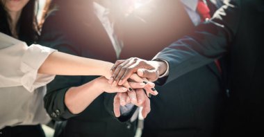 Close up of multiethnic business people putting hands together. business collaborate coworkers with stack of hands showing unity and teamwork.