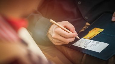 Kredi kartı ödeme faturası ve el ele tutuşma kalemi ile dükkânda ödeme yapmaya hazır.