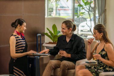 Kafkas yolcu misafiri, lobiye vardıktan sonra otel kontrollerini beklerken Asya Otel resepsiyonuna hoş geldin içkisi için bahşiş veriyor.