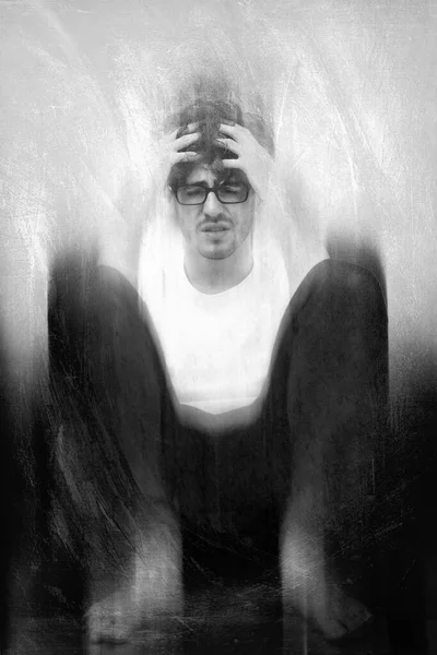black and white high grain dramatic fine art portrait of caucasian man in emotional and nervous mind of stress despair and depression. Concept of psycho or drug addict man in illusion and paranoid
