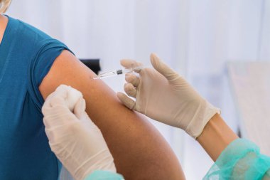 Koronavirüs kovid 19 aşı şırıngası hastanın omzuna enjekte edilecek. Coronavirus covid-19 aşısı