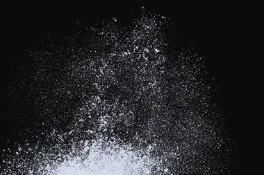 Sahile vuran deniz dalgası, siyah zemin üzerinde izole edilmiş beyaz su köpüğü ve kabarcık püskürtüyor.