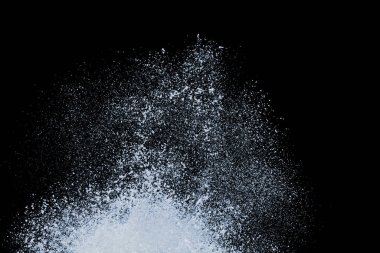 Sahile vuran deniz dalgası, siyah zemin üzerinde izole edilmiş beyaz su köpüğü ve kabarcık püskürtüyor.