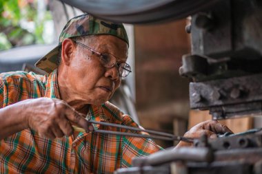 Bangkok, Tayland: Temmuz 2018 - Yerel el sanatları işçisi bronz çatal ve kaşık sofra takımı yapıyor
