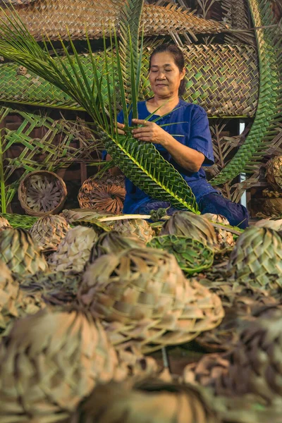 サムットソンクラーム県の農村部のヤシの葉から手作りのタイの伝統的な帽子のバスケットを織る女性職人 — ストック写真